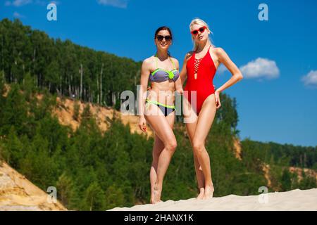 Porträt von zwei jungen Frauen in Badeanzügen posiert auf der Strand Stockfoto