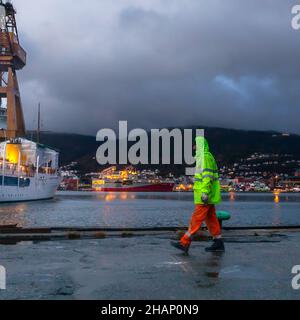 Arbeiter an einem Trockendock auf der alten BMV-Werft in Laksevaag, in der Nähe des Hafens von Bergen, Norwegen. Die Royal Yacht im Hintergrund, die möglicherweise darauf wartet, den zu betreten Stockfoto