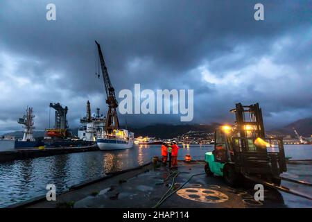 Arbeiter an einem Trockendock auf der alten BMV-Werft in Laksevaag, in der Nähe des Hafens von Bergen, Norwegen.die Royal Yacht im Hintergrund, möglicherweise warten auf die Einschiffung Stockfoto