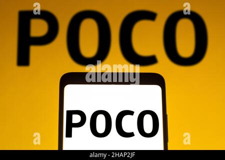 In dieser Abbildung wird ein POCO-Logo auf einem Smartphone und im Hintergrund angezeigt. Stockfoto