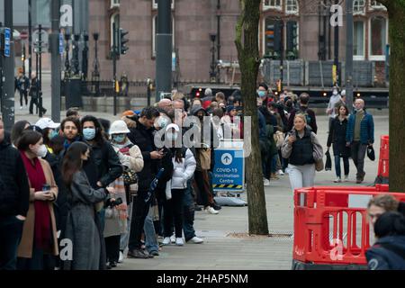 Manchester, Großbritannien, 14th. Dezember 2021. Mitglieder der Öffentlichkeit stehen in einer Impfstelle im Zentrum von Manchester an, da die Befürchtungen wachsen, dass die Omicron-Variante die Regierung dazu zwingen wird, Teile der Wirtschaft zu schließen. Kredit: Jon Super/Alamy Live Nachrichten. Stockfoto