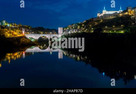 Die Alcantara-Brücke von Toledo Spanien Reflektierte auf dem Fluss Tejo in der Nacht Stockfoto