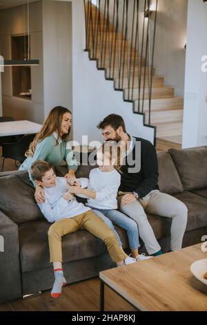 Niedliche Geschwister kämpfen zu Hause um die Fernbedienung des Fernsehers Stockfoto