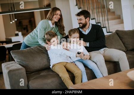 Niedliche Geschwister kämpfen zu Hause um die Fernbedienung des Fernsehers Stockfoto