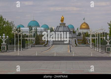 Goldene Statue von Saparmurat Nijasov im 10 Jahre Unabhängigkeitspark in Aschgabat, der Hauptstadt Turkmenistans. Oguzkhan Präsidentenpalast im Hintergrund Stockfoto