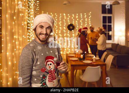 Portrait von glücklichen Mann in hässlichen Weihnachtspullover und Weihnachtsmann Hut auf Weihnachtsfeier Stockfoto