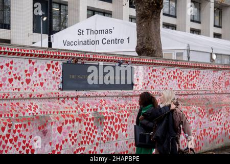 Da die Anzahl der Omicron Covid-Variantenfälle im Vereinigten Königreich zunimmt und die Beschränkungen des Plans B der Regierung fortbestehen, wird das Impfzentrum außerhalb des NHS-Krankenhauses von St. Thomas hinter der National Covid Memorial Wall gesehen, deren rote Herzen den Tod von Covid am 14th. Dezember 2021 in London, England, in der Familie verzeichnen. Stockfoto