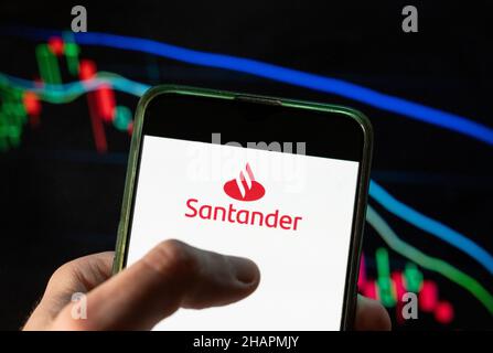 China. 4th Dez 2021. In dieser Abbildung ist das spanische Logo der multinationalen Geschäftsbank und der Finanzdienstleistungsbank Santander zu sehen, das auf einem Smartphone mit einem Index der wirtschaftlichen Börse im Hintergrund dargestellt ist. (Bild: © Budrul Chukrut/SOPA Images via ZUMA Press Wire) Stockfoto