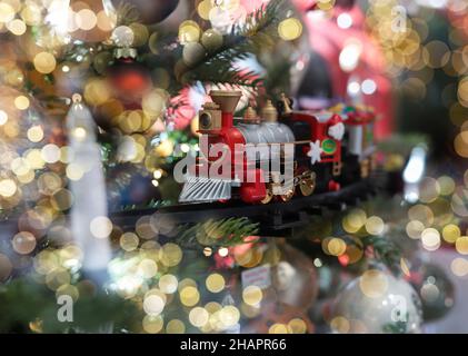 Minsk, Weißrussland - Oktober 28 2021 Zugspielzeug als Ornament auf Weihnachtsbaum mit verschwommenem Licht. Stockfoto