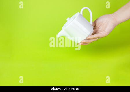 Cute White Keramik Teekannen vor hellgrünem Hintergrund. Moderner Stil Stockfoto