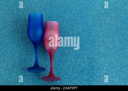 Zwei blaue Sektgläser auf glänzend blauer Oberfläche mit Kopierfläche, Draufsicht. Stockfoto