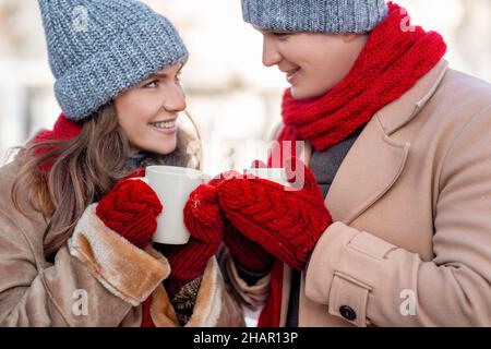 Glücklicher Mann und Frau wärmen sich auf, trinken heißen Tee, Nahaufnahme Stockfoto