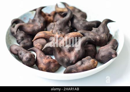 Chinesischer Ling Jiao (Wasserkaltrop) in einer Platte isoliert auf weißem Hintergrund. Stockfoto