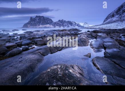 Felsiger Strand im Winter. Küste mit Steinen, verschwommenes Wasser Stockfoto