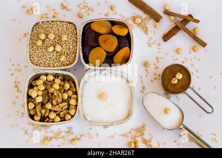 Ungekochte Zutaten von traditionellem Dessert Asure, Noah Puding in Aluminiumschüsseln, Folienbehältern – zum Mitnehmen auf der weißen Oberfläche Stockfoto