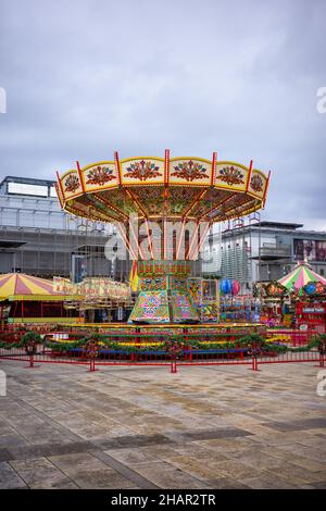 Das Winterwunderland von Bristol mit Fahrgeschäften auf dem Millennium Square in Bristol. (Dec21) Stockfoto