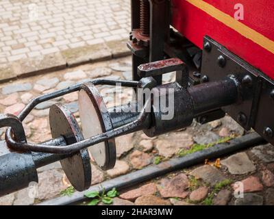 Alte Straßenbahnkupplung auf dem Hintergrund von Kopfsteinpflaster. Art der Verbindung zwischen Straßenbahnwagen, Nahaufnahme Stockfoto