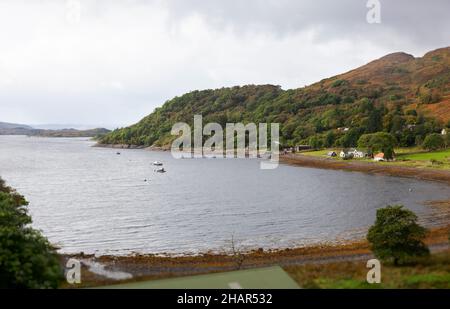 Erhöhter Blick auf die kleine Siedlung von Häusern an der abgeschiedenen Laga Bay am Loch Sunart, in der Nähe von Glenborgdale in West Schottland Stockfoto