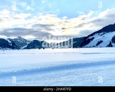 Landschaft der Langlaufregion rund um das Dorf Studen, Schweiz im Winter. Es liegt auf flachen und Ebenen Feldern. Stockfoto