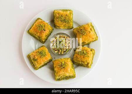 Traditionelles türkisches Gebäck Dessert Dry Baklava, in runder Platte mit Pistazien-Nüssen entworfen.Draufsicht Stockfoto