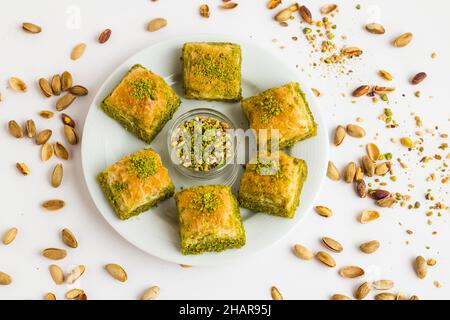 Traditionelles türkisches Gebäck Dessert Dry Baklava in runder Platte mit Pistazien auf weißer Oberfläche, Draufsicht Stockfoto