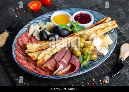 Verschiedene italienische Vorspeisen mit Grissini auf einem Teller. Stockfoto