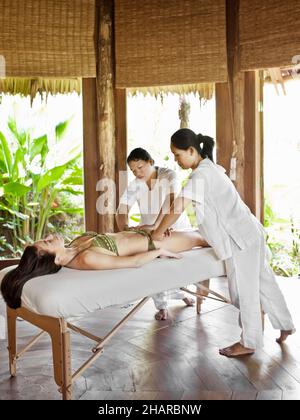 Eine Frau erhält eine vierhändige Massage im Behandlungsraum 4 im Six Senses Spa. Diese Massage ist Teil der Six Sensory Journey-Behandlung. Sechs Sinne Stockfoto