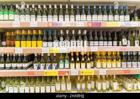 In einem Supermarkt in Kent UK werden vier Reihen Weißweine in den Regalen am Getränkegang ausgestellt Stockfoto