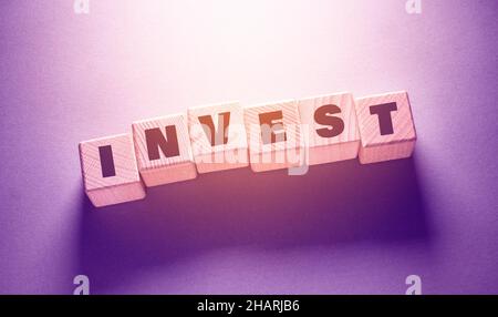 Invest Word geschrieben auf Holzwürfel Stockfoto