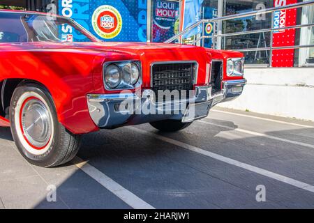 BANG, THAILAND - 14. Dez 2021: Ein rotes Oldtimer oder Muscle-Car steht vor einem Geschäft Stockfoto