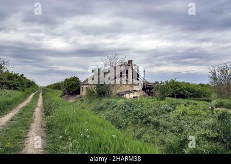 Die schöne Aufnahme der Ruinen eines alten Hauses stürzte wegen der Verschlechterung auf dem Feld ein Stockfoto