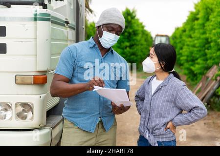 Mann und Frau in Masken reden Stockfoto