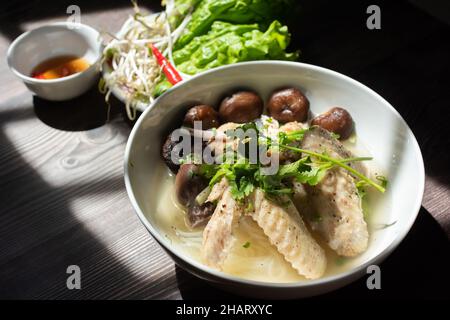 Hühnerpilz-Nudelsuppe ist ein sehr beliebtes Frühstücksgericht in Vietnam. Zu den Zutaten gehören Reisnudeln, Pilze, Huhn, Gemüse und spi Stockfoto