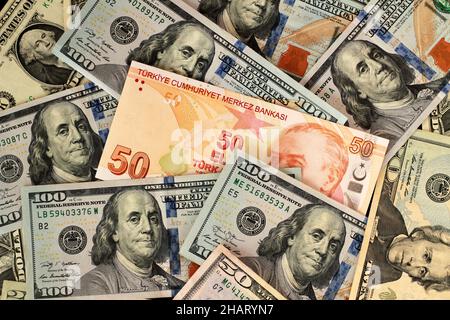 Türkische Fifty Lira Banknote in amerikanischen Dollar-Banknoten, monetärer Hintergrund mit flachem Layout-Bild Stockfoto