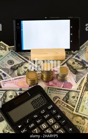 Weißes und leeres Smartphone mit türkischer Lira und US-Dollar und Rechner, vertikales Bild Stockfoto