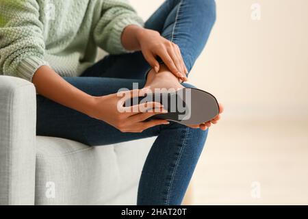 Frau, die zu Hause orthopädische Einlegesohle passt Stockfoto