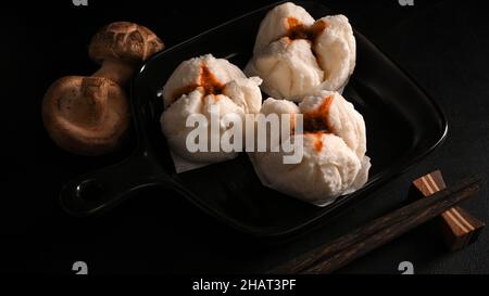 Chinesische gedämpfte rote Schweinebasen oder gedünstete BBQ-Schweinebasen auf einem Teller. Traditionelles asiatisches Gourmet-Restaurant. Stockfoto