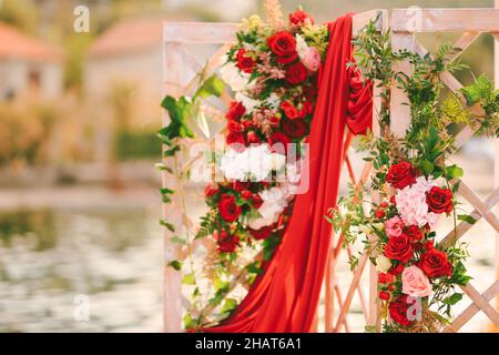 Hölzerne klappbare Hochzeitsleinwand mit Blumen und Drapierwaren verziert Stockfoto