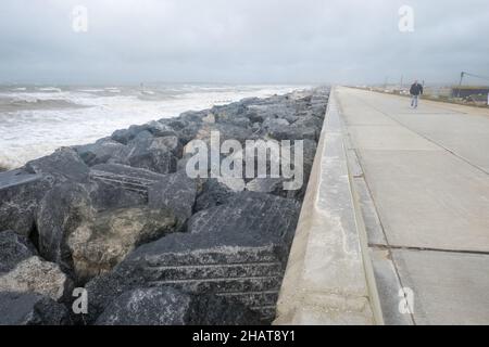 Mann, auf, Promenade, Ufer, Wellen, die, Wetter, täglich, im Freien, im Freien, Sport, Wandern, Promenade, Strandpromenade, Seeverteidigung, Seeverteidigung, Meer, Ärmelkanal, Wetter, raue Meere, wild, Bedingungen, Sturm, stürmisch, windig, Wind, Wetter, auf, Küste, Küste, Dungeness, Kent, England, Englisch, GB, Großbritannien, Großbritannien, Großbritannien, Großbritannien, Europa, Europa, Europa, Tag, August, Sommer, Sommer Stockfoto