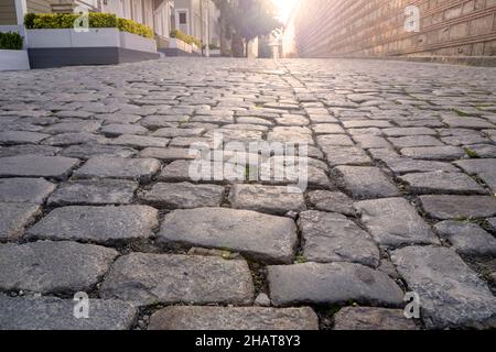 Leere alte Kopfsteinpflasterstraße und Sonnenlicht am Morgen Stockfoto