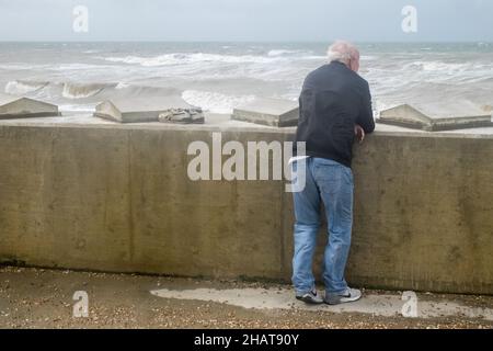 Mann, auf, Promenade, Ufer, Wellen, die, Wetter, täglich, im Freien, im Freien, Sport, Wandern, Promenade, Strandpromenade, Seeverteidigung, Seeverteidigung, Meer, Ärmelkanal, Wetter, raue Meere, wild, Bedingungen, Sturm, stürmisch, windig, Wind, Wetter, auf, Küste, Küste, Dungeness, Kent, England, Englisch, GB, Großbritannien, Großbritannien, Großbritannien, Großbritannien, Europa, Europa, Europa, Tag, August, Sommer, Sommer Stockfoto