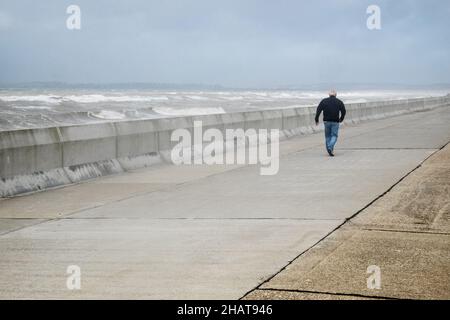 Mann, auf, Promenade, Ufer, Wellen, die, Wetter, täglich, im Freien, im Freien, Sport, Wandern, Promenade, Strandpromenade, Seeverteidigung, Seeverteidigung, Meer, Ärmelkanal, Wetter, raue Meere, wild, Bedingungen, Sturm, stürmisch, windig, Wind, Wetter, auf, Küste, Küste, Dungeness, Kent, England, Englisch, GB, Großbritannien, Großbritannien, Großbritannien, Großbritannien, Europa, Europa, Europa, Tag, August, Sommer, Sommer Stockfoto