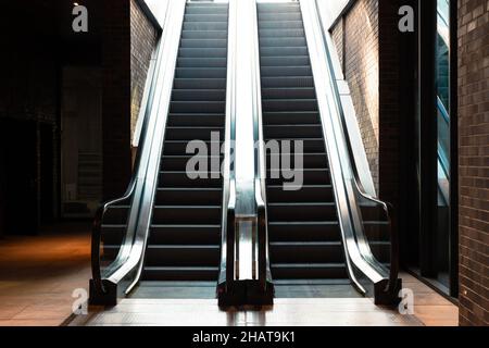 Rolltreppen. Zwei Rolltreppen im Gebäude. Business oder Architektur oder Bau oder Einkaufen oder unterirdisches Hintergrundfoto. Stockfoto