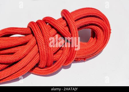 Segelseil auf dem Schiffsdeck. Anlegeseil rote Farbe auf dem Segelboot Bogen Hintergrund. Nahaufnahme, Segelbootsfahrt in der Ägäis, Griechenland Stockfoto