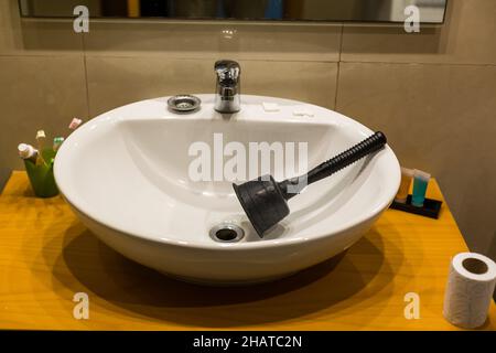 Nahaufnahme von Klempnern mit Kolben im Waschbecken. Stockfoto