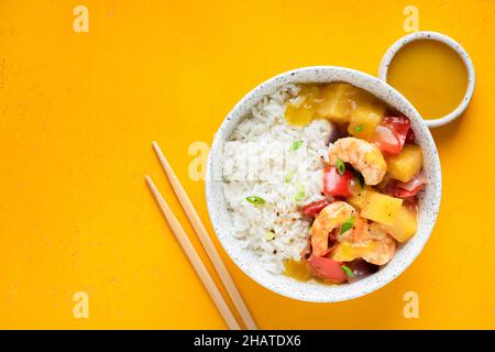 Garnelen Ananasreis in einer Schüssel, asiatische Küche. Gelber Hintergrund, Draufsicht Stockfoto