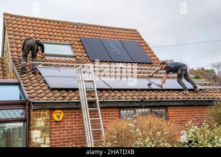 Arbeiter installieren Solarzellen oder pv-Zellen auf dem Pantiled Dach eines Norfolk-Häuschens. NB: Die Räumlichkeiten auf dem Foto sind Eigentum freigegeben. Stockfoto