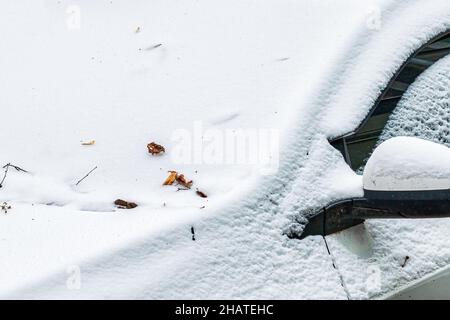 An einem Wintertag war die Windschutzscheibe eines gefrorenen Autos bedeckt und der Rückspiegel war mit Eis und Schnee bedeckt. Nahaufnahme. Stockfoto