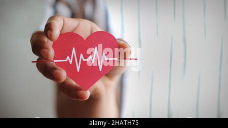 Mann Hand hält rotes Herz mit Kardiogramm, Gesundheitsversorgung, Organspende, Familie Lebensversicherung, Welt Herz Tag, Weltgesundheitstag, Gebetskonzept Stockfoto