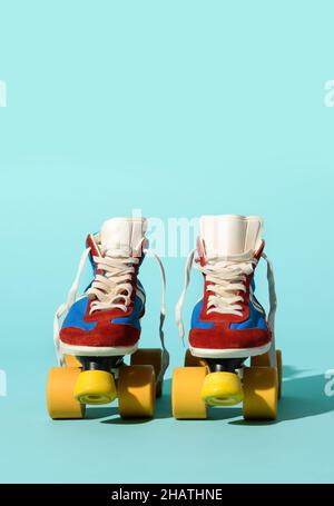 Isoliertes Paar altmodischer Rollschuhe auf hellblauem Hintergrund im Studio Stockfoto